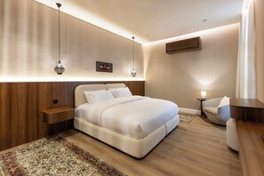 A modern bedroom with a large bed, bedside tables, a nightstand, a wall-mounted shelf, and a hanging light fixture. - Atrah Elite 3BR Sanctuary in Shuran (Madinah)