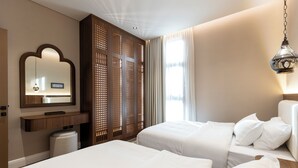 Ein Hotelzimmer mit zwei Betten, einer Holzwand, einem Spiegel und einer Pendelleuchte.
