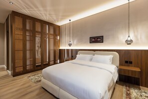 A bedroom with a large bed, wooden headboard, and a decorative wall panel. - Atrah Elite 3BR Sanctuary in Shuran (Madinah)