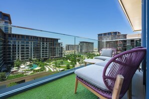 A balcony with a view of surrounding buildings and a pool area. - Elegant 2BR Haven in Viridian by Central Park (Dubai)