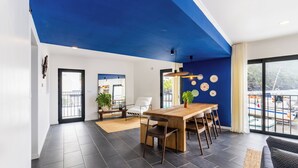 Een modern interieur met een eethoek, een bank en uitzicht op het groen.