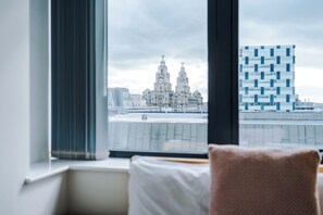 Ein Hotelzimmer mit Blick auf ein historisches Gebäude und ein modernes Glasgebäude.