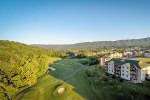 A golf course with a large building adjacent to it. - The Summit Two Bedroom Condo (Mc Gaheysville)