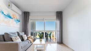 Una sala moderna con un sofá, una mesa de centro y vistas a un balcón.