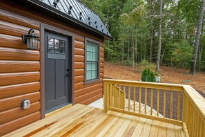 A log cabin with a front door, a window, a deck, and a metal roof. - Shenandoah, Firepit, peaceful Cabin w/salt water Hot tub! (Luray)