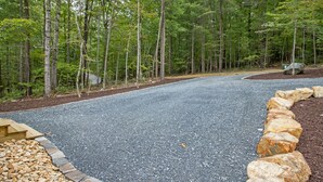 Una strada sterrata con bordi in pietra, immersa in una foresta.