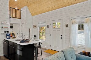 A kitchen with a white countertop, black cabinets, and a wooden ceiling. - Shenandoah, Firepit, peaceful Cabin w/salt water Hot tub! (Luray)
