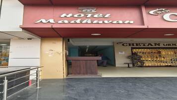 Exterior del Hotel Madavan, con mostrador de recepción y entrada visible.