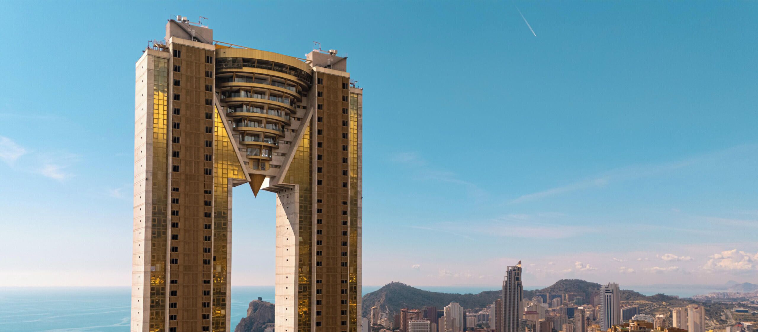 Un edificio moderno con un design architettonico originale, caratterizzato da un'ampia atrio centrale e numerosi balconi.