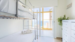 A modern hotel room with a bunk bed, a desk, a plant, and a view of the city. - Intempo by Holuxe - 075 - 7th floor (Benidorm)