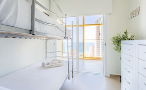 A modern hotel room with a bunk bed, a desk, a plant, and a view of the city. - Intempo by Holuxe - 075 - 7th floor (Benidorm)