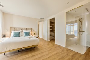 Ein modernes Schlafzimmer mit einem großen Bett, Nachttischen, einem begehbaren Kleiderschrank und einer Duschkabine.