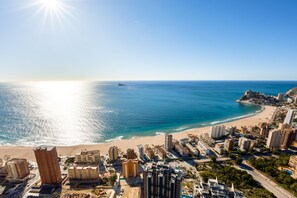 Eine Küstenstadt mit Hochhäusern, einem Strand und einem klaren Himmel.
