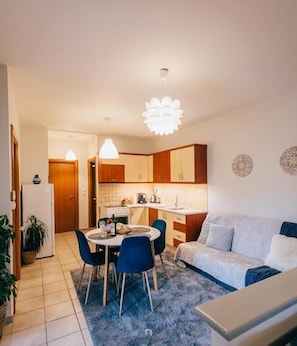 A compact living space with a dining area, kitchenette, and a sofa. - Kalavrita Milodesi Country House with Fireplace (Kalavrita)