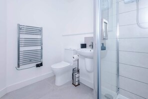 A modern bathroom with a toilet, bidet, and glass shower enclosure. - Stylish 1BDR Hospitals Nearby (Liverpool)