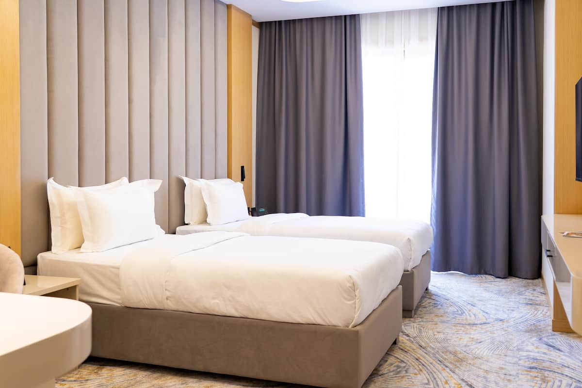 Una habitación de hotel con dos camas, un escritorio y una silla.