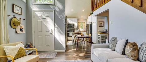 A spacious living area with a sofa, a dining table, and a kitchen in the background.