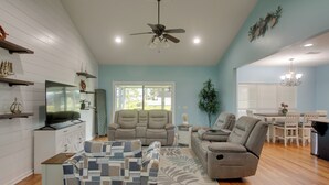 A spacious living room with a ceiling fan, a flat-screen TV, a sofa, a recliner, and a dining area with a table and chairs. - Peaceful Lake Escape w/ Dock in Coffee County (Douglas)