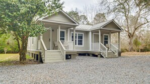 A two-story house with a porch, a staircase, and a gravel driveway. - Group-friendly Escape! Gateway to Gulfport Beaches (Gulfport)