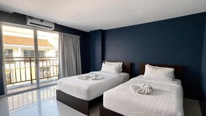 A hotel room with two beds, a balcony with a view, and an air conditioning unit. - Central Perk Patong (Patong)