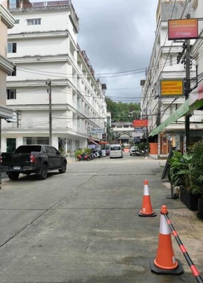 A street with buildings, a parked truck, and traffic cones. - Central Perk Patong (Patong)
