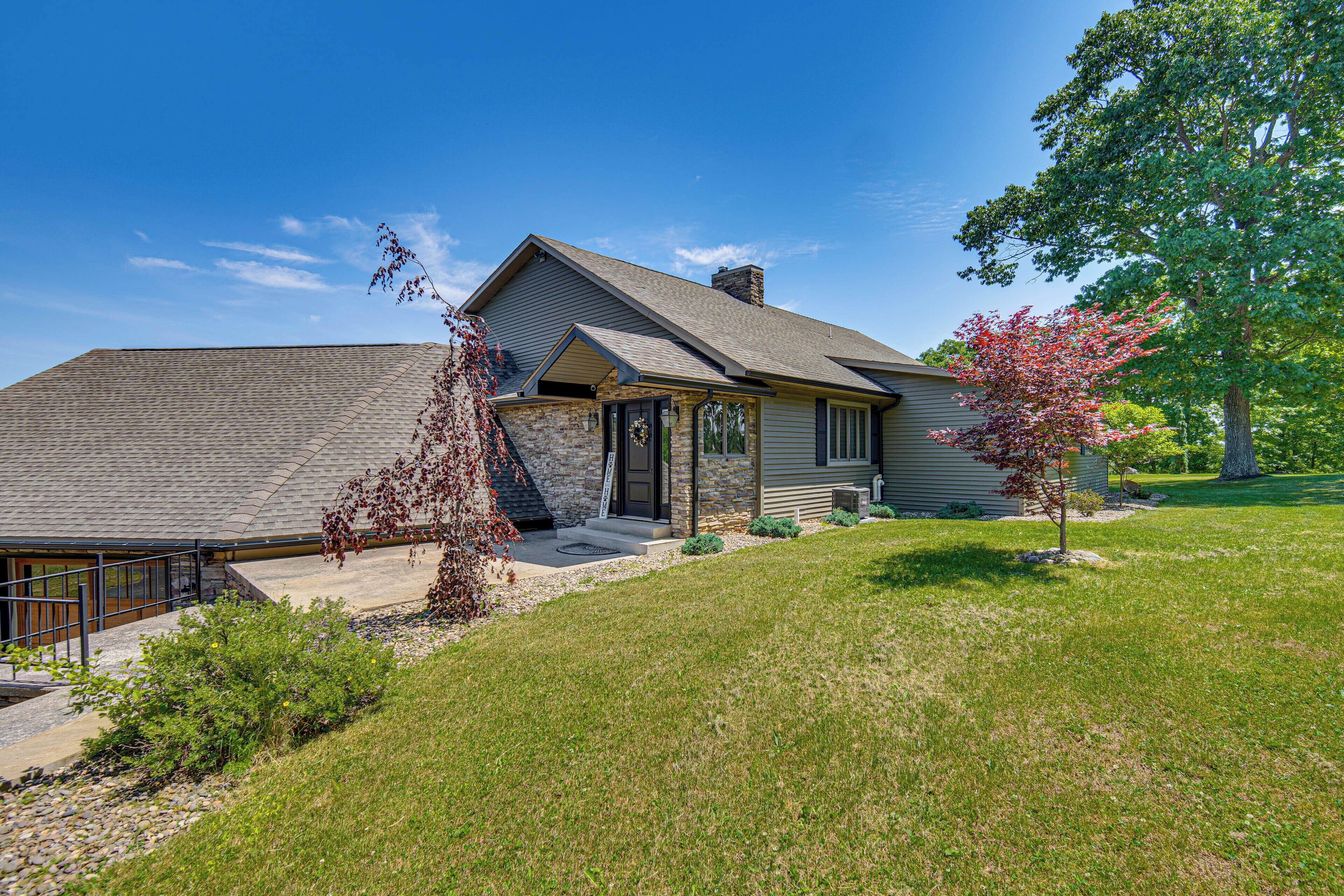 A single-story house with a stone facade, a front porch, and a well-maintained lawn.