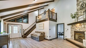 A spacious living area with a high ceiling, a staircase, a fireplace, and a cozy seating area. - Pool, Hot Tub + Views: Spacious Danville Escape! (Danville)