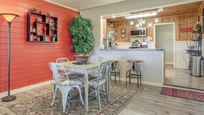 A dining area with a table and chairs, a red wall, and a kitchen in the background. - Walk to Shops & Eats! Family Escape in Columbus (Columbus)