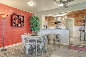 A dining area with a table and chairs, a red wall, and a kitchen in the background. - Walk to Shops & Eats! Family Escape in Columbus (Columbus)