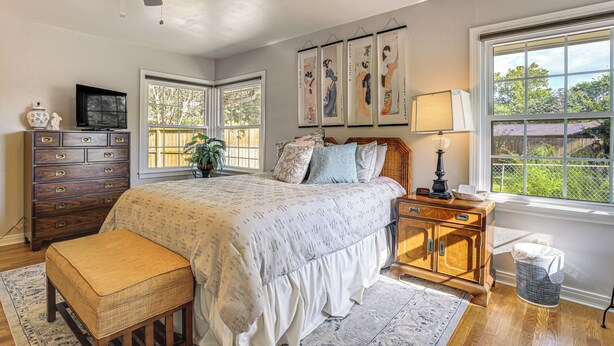 A bedroom with a bed, dresser, nightstand, and a ceiling fan. - Walk to Shops & Eats! Family Escape in Columbus (Columbus)