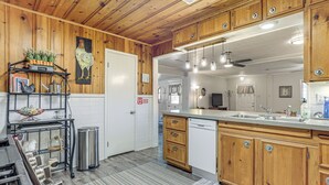 A kitchen with wooden cabinets, a dishwasher, and a stainless steel sink. - Walk to Shops & Eats! Family Escape in Columbus (Columbus)