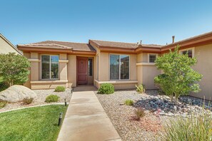A residential house with a front entrance, a pathway leading to the door, and a small garden area with rocks and plants. - Near Zion! Extended Desert Retreat w/ Pool Access (Washington)
