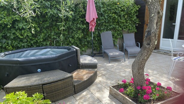 A hot tub, lounge chairs, and a garden with flowers. - Self-contained apartment in the heart of the garrigues. Spa garden. pets allowed (Pignan)