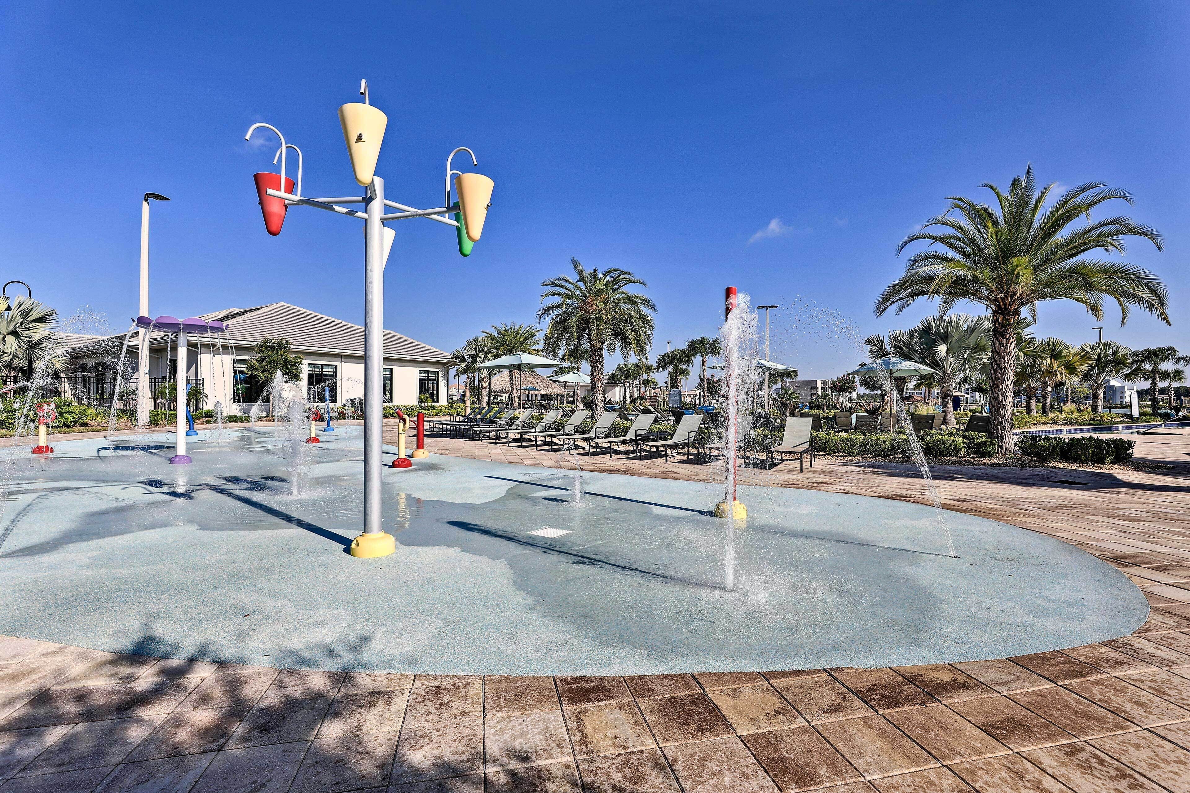 A water feature with multiple jets, surrounded by palm trees and lounge chairs.