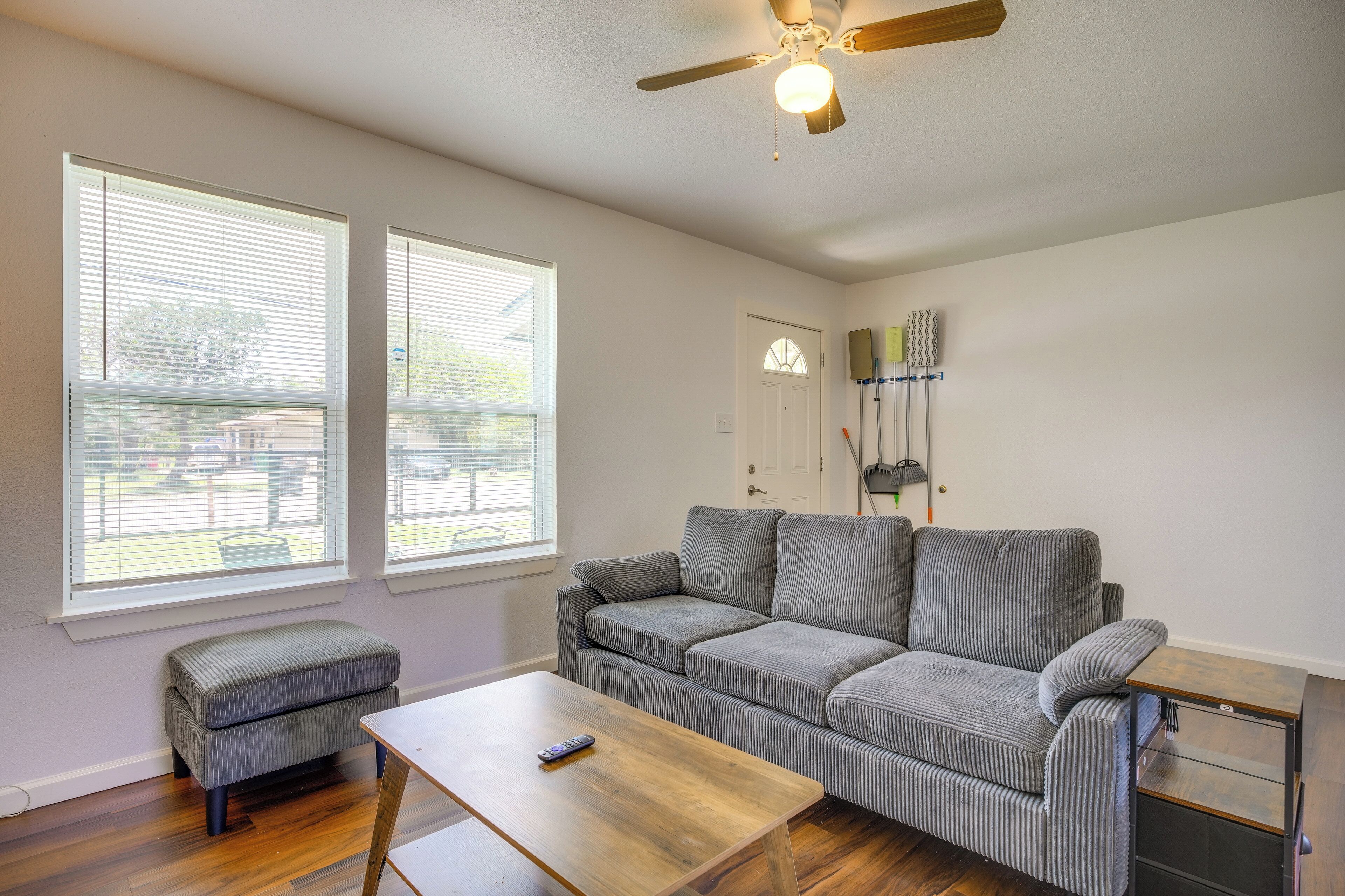 A living room with a sofa, ottoman, and a coffee table.