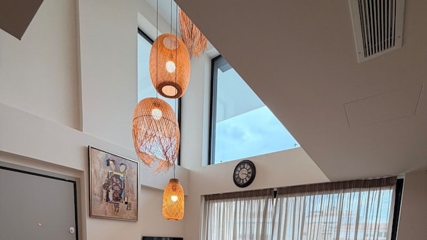 Una sala de estar moderna con un sofá, una mesa de centro y lámparas colgantes.