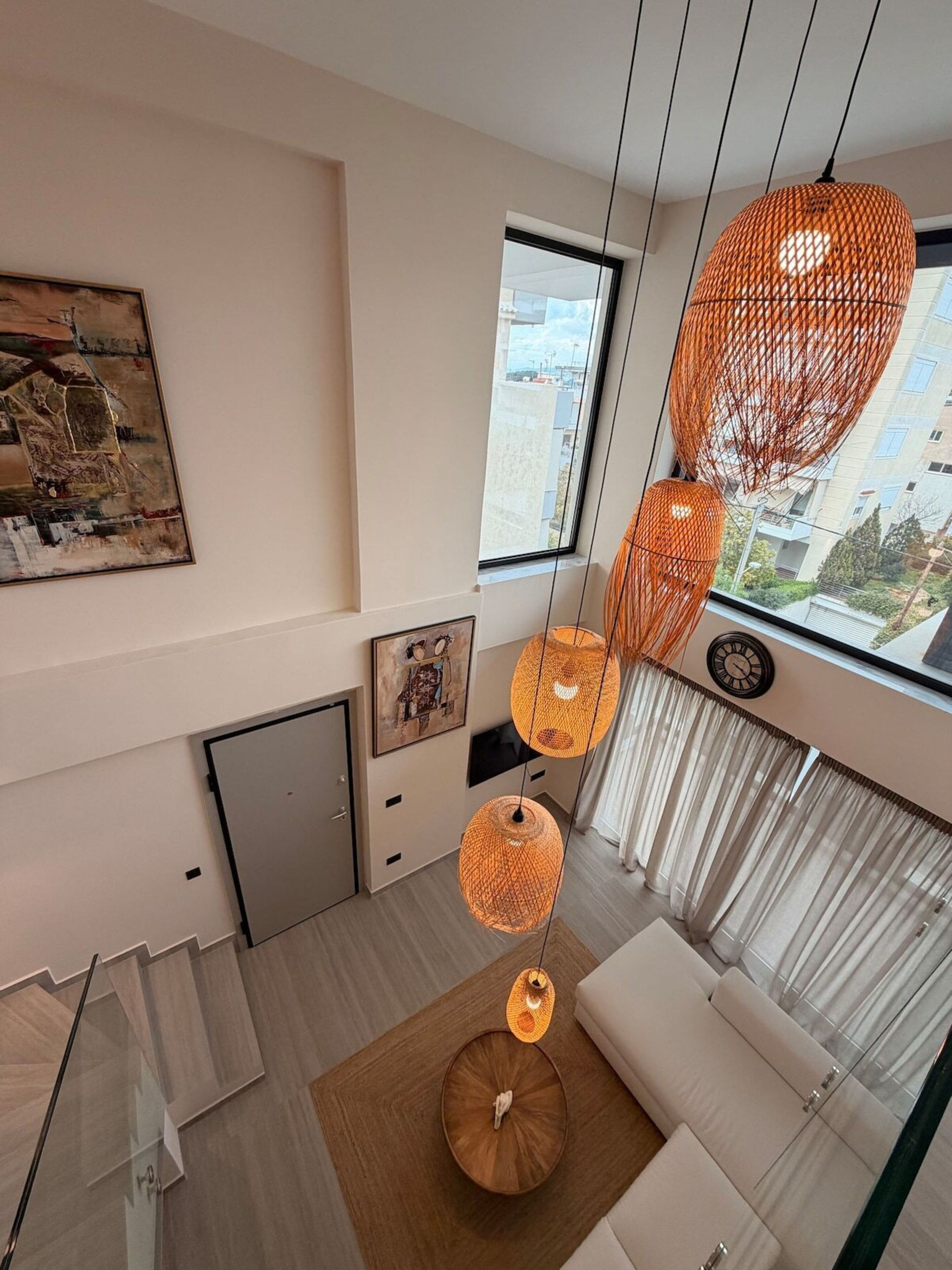 Una sala de estar moderna con un sofá, una mesa de comedor y un ventanal con vistas a edificios.