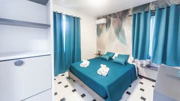 Apartamento, 3 quartos, ar-condicionado | Cofres nos quartos, ferros/tábuas de passar roupa, Wi-Fi de cortesia