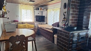 Un espace de vie compact comprenant un coin repas, une kitchenette et un téléviseur.
