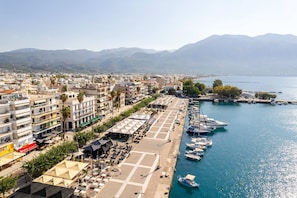 A coastal cityscape with a marina, buildings, and mountains in the background. - Modern City-center Studio in the Heart of Kalamata (Kalamata)