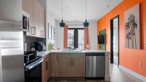 Une cuisine moderne avec des meubles en bois, des appareils en acier inoxydable et un grand îlot central.