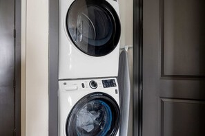 A stacked washer and dryer unit with a control panel and a visible door. - Sapphire Shores Lakeside Escape Pet Friendly (Rowlett)