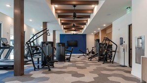 A gym with exercise equipment, a treadmill, and a blue wall. - Sapphire Shores Lakeside Escape Pet Friendly (Rowlett)