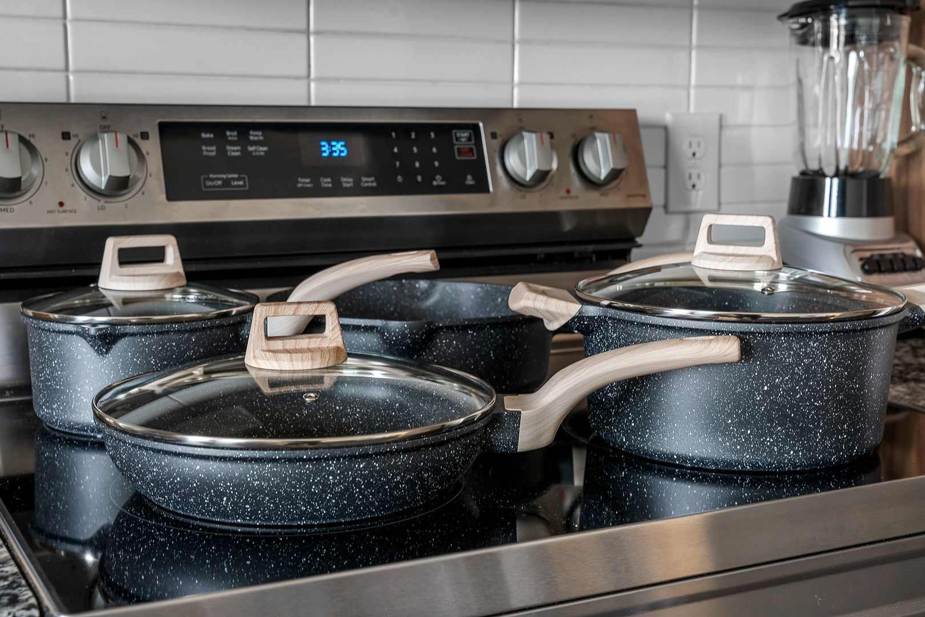 Une cuisine équipée d’une cuisinière, de casseroles et d’une horloge numérique.