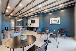 A modern interior with a kitchen area, dining space, and seating. - Dallashaus Pool Gym Love Field (Dallas)