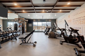 A gym with treadmills, stationary bikes, and free weights. - Dallashaus Pool Gym Love Field (Dallas)