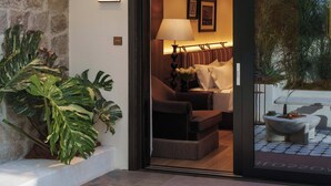 A hotel room with a bed, a nightstand, a lamp, and a view of the outside. - BLOSSOM Floral Art Aesthetic Villa (Dali)