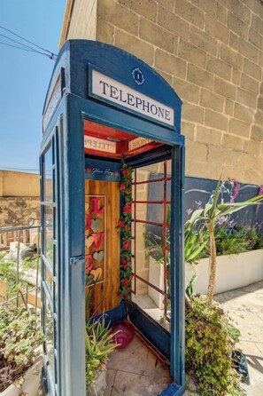 Eine Telefonzelle mit einem Schild mit der Aufschrift 'TELEPHONE' und einem Holzinnenraum.