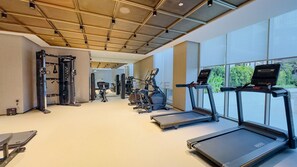 Ein Fitnessstudio mit Laufbändern, Kraftgeräten und einem Boxsack.