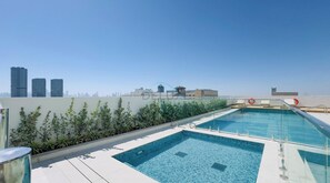 Ein Pool auf dem Dach mit einer Stadtansicht im Hintergrund.